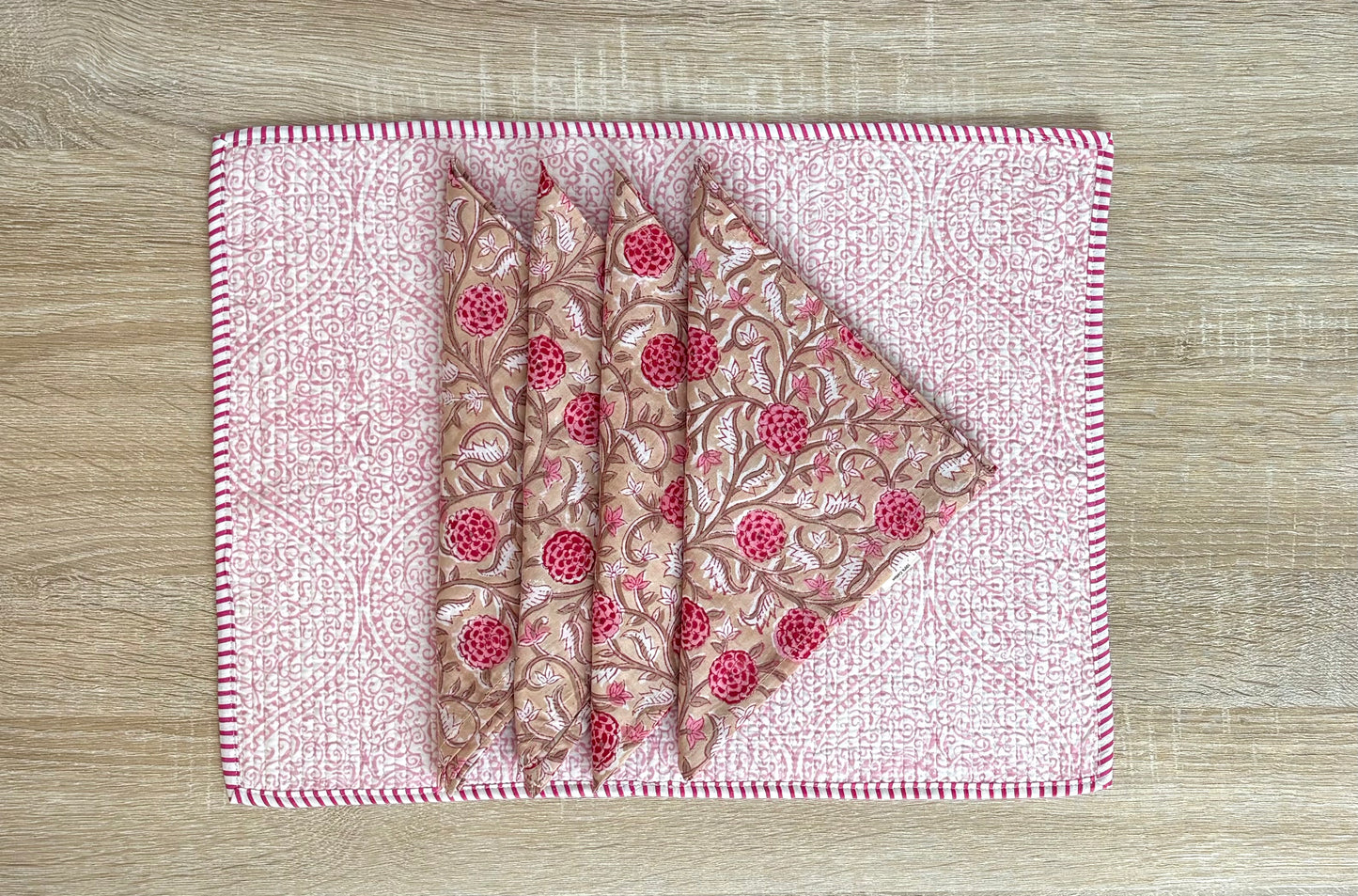 Two folded fabric pieces with a floral pattern on a matching fabric background.