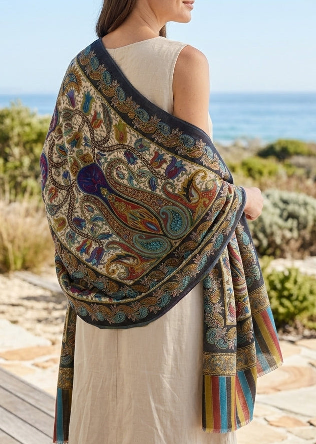 Woman wearing a colorful patterned shawl by the ocean