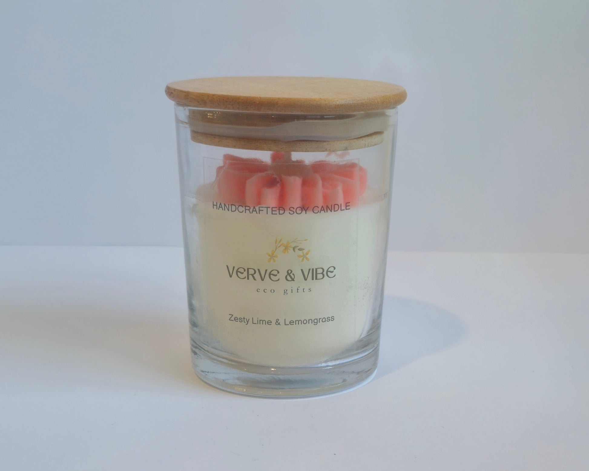 Glass candle with wooden lid on a white surface