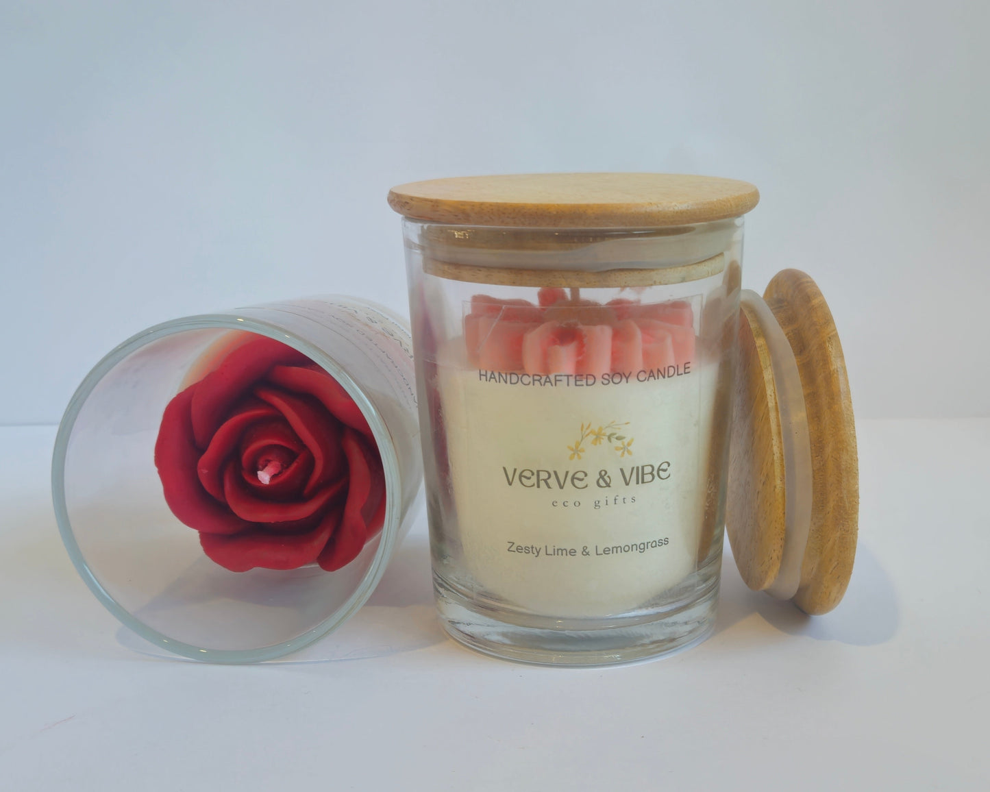 Glass container with a preserved red rose and a candle labeled 'Vivere & Vivere' on a white surface.