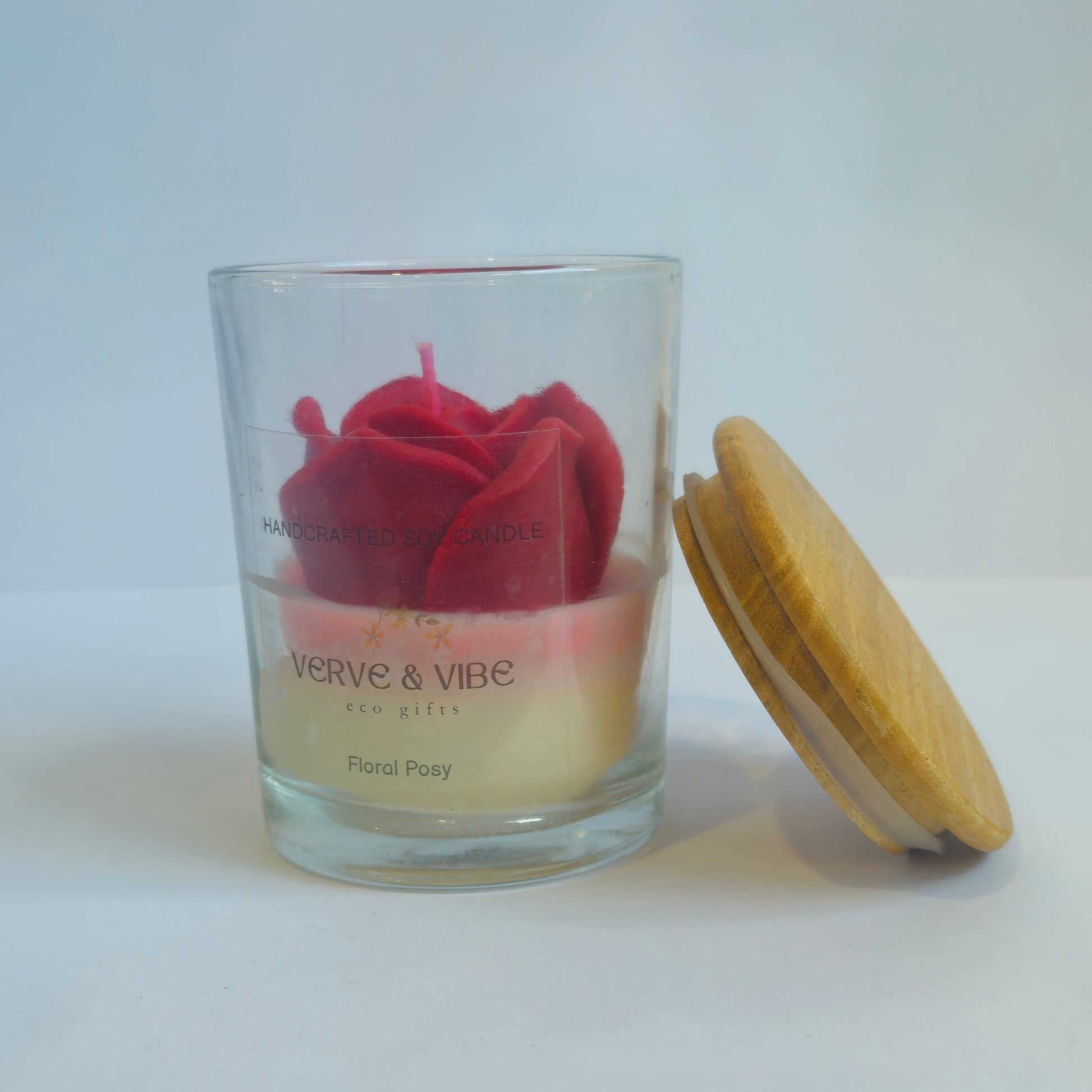 Glass candle with a red heart design on a white surface
