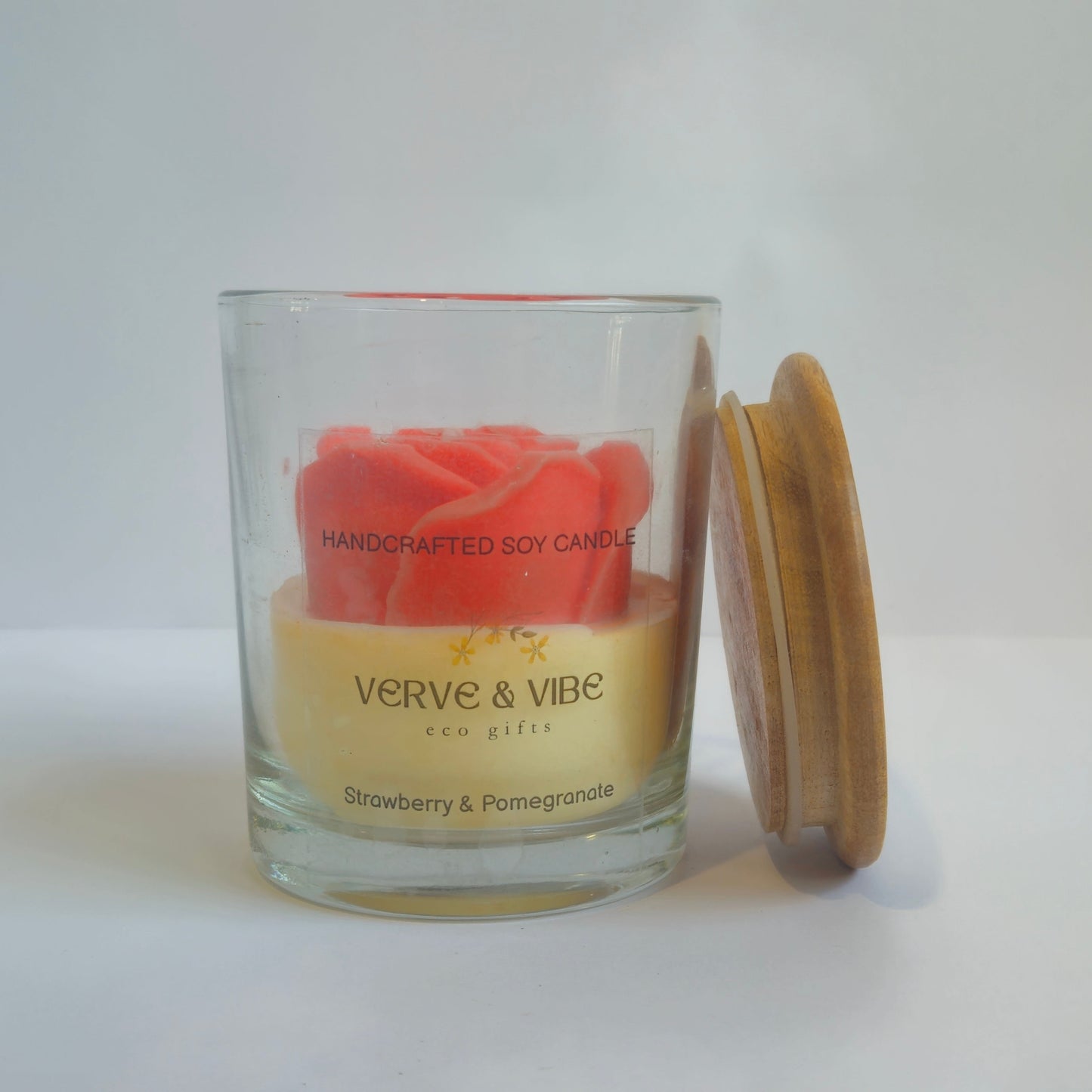 Glass candle jar with wooden lid on a white surface