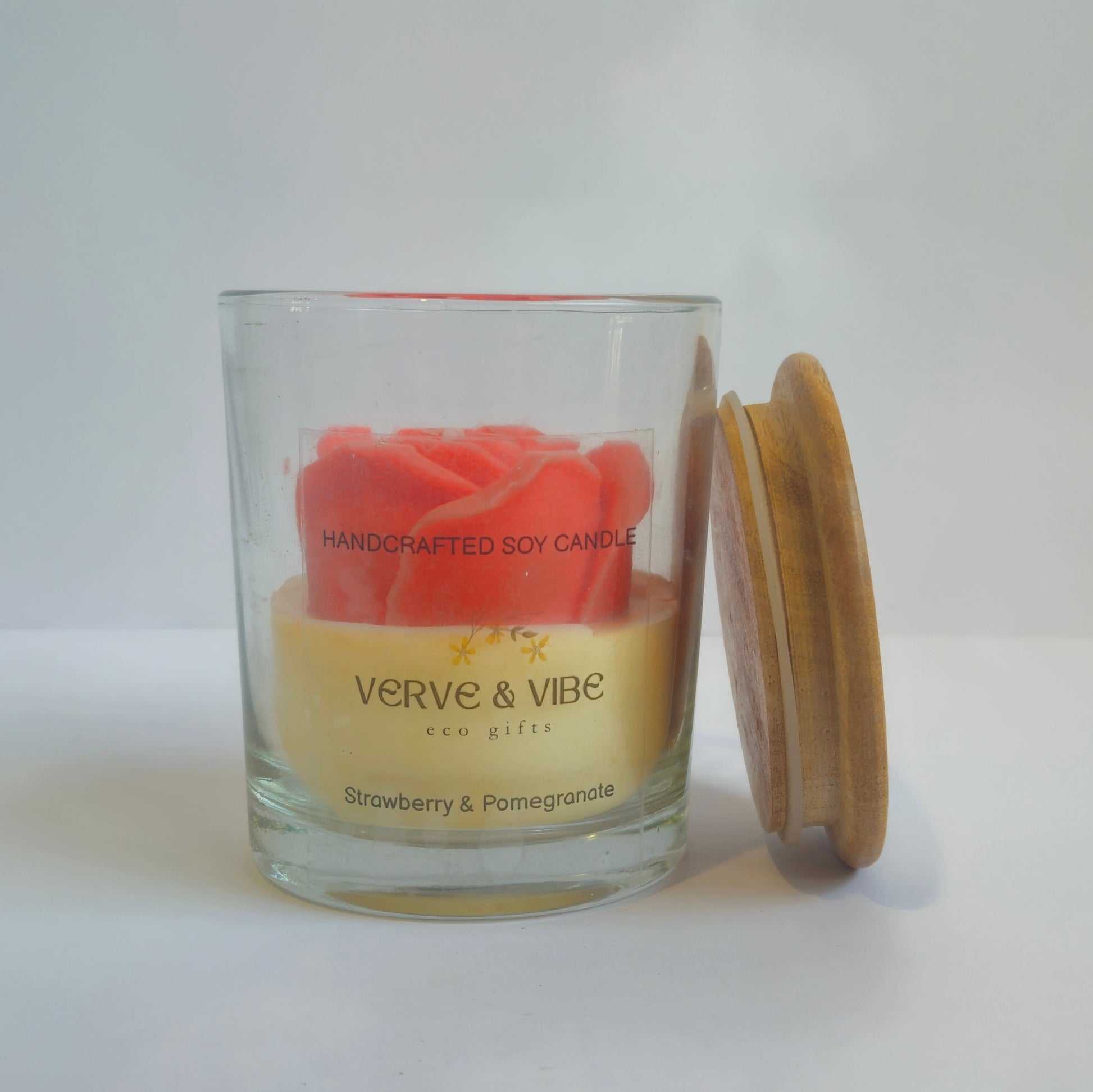 Glass candle jar with wooden lid on a white surface