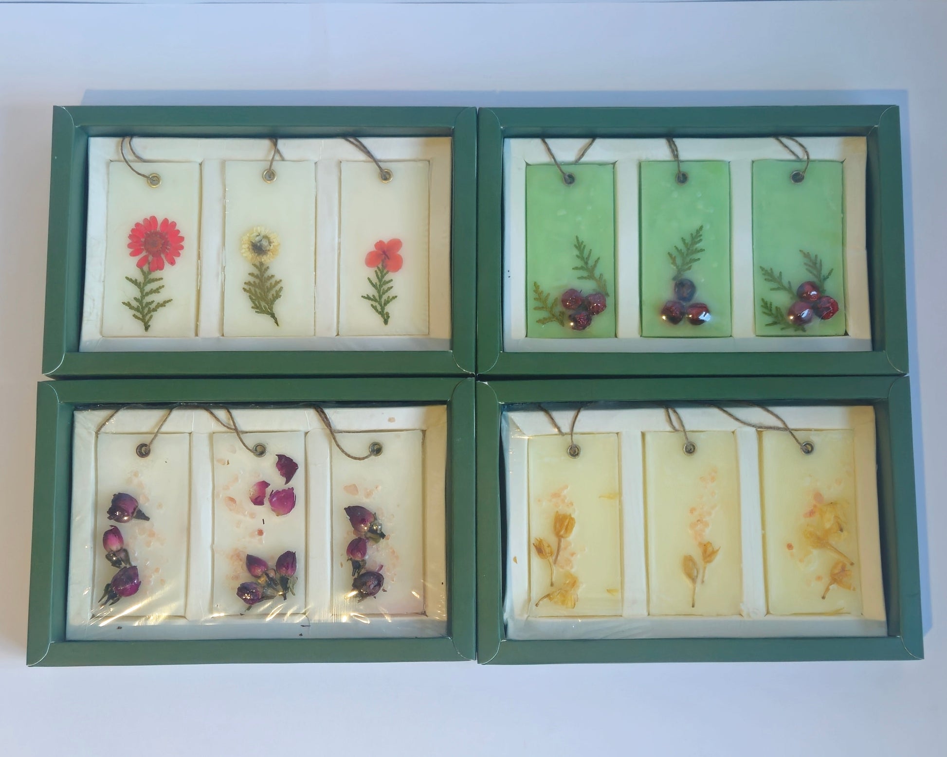 Set of four framed botanical prints on a white surface with a floral-patterned chair in the background.