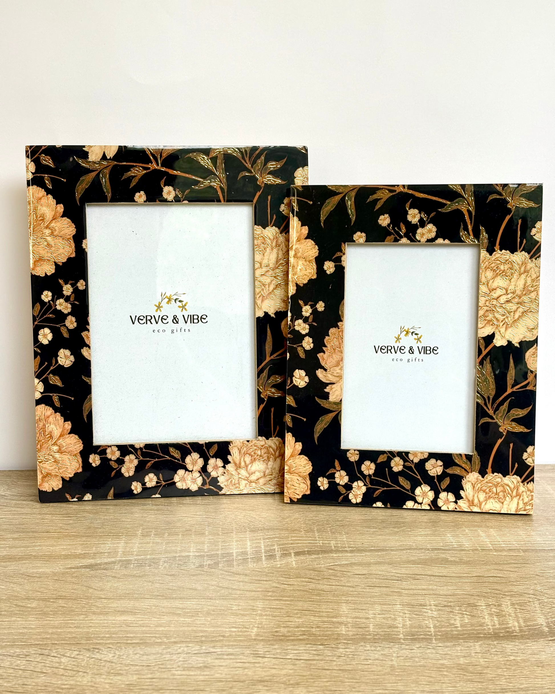 Two floral photo frames with 'Verve & Vibe' branding on a wooden surface.