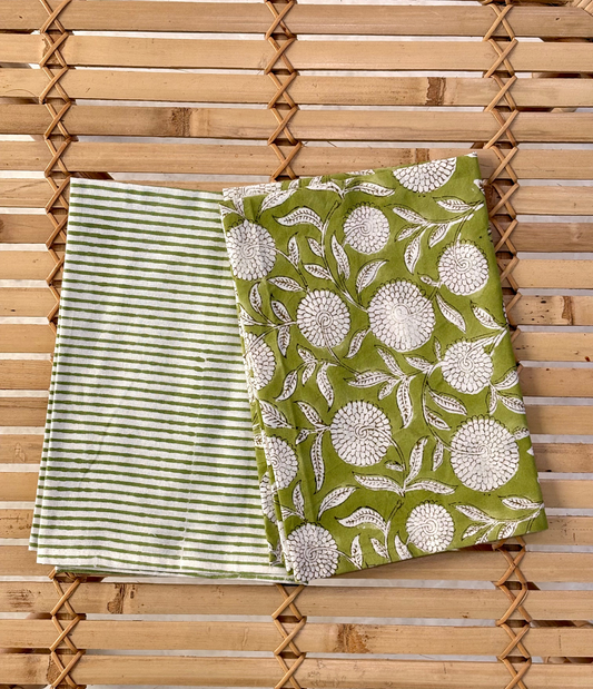 Two green fabrics with different patterns on a wooden background