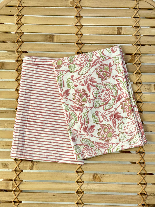 Two fabric swatches, one striped and one floral, against a wooden slat background.