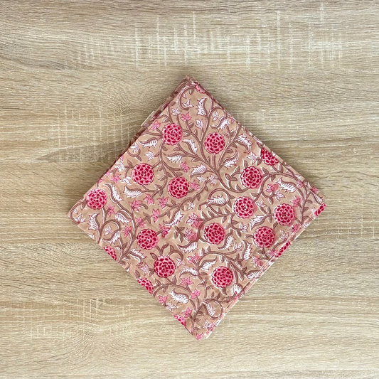 Folded pink fabric with floral pattern on a wooden surface