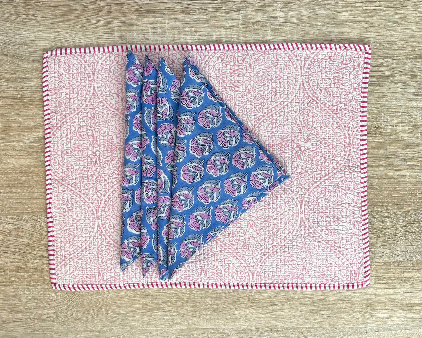 Folded fabric with blue and pink pattern on a wooden surface