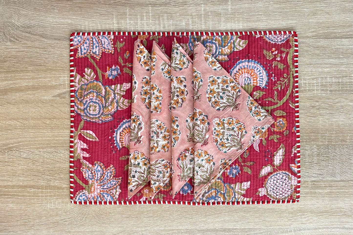 Decorative pink fabric with floral patterns on a wooden surface