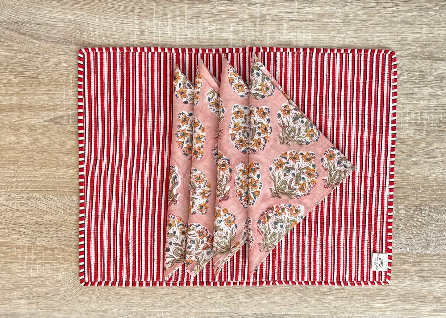 Floral fabric on a red and white striped mat on a wooden surface