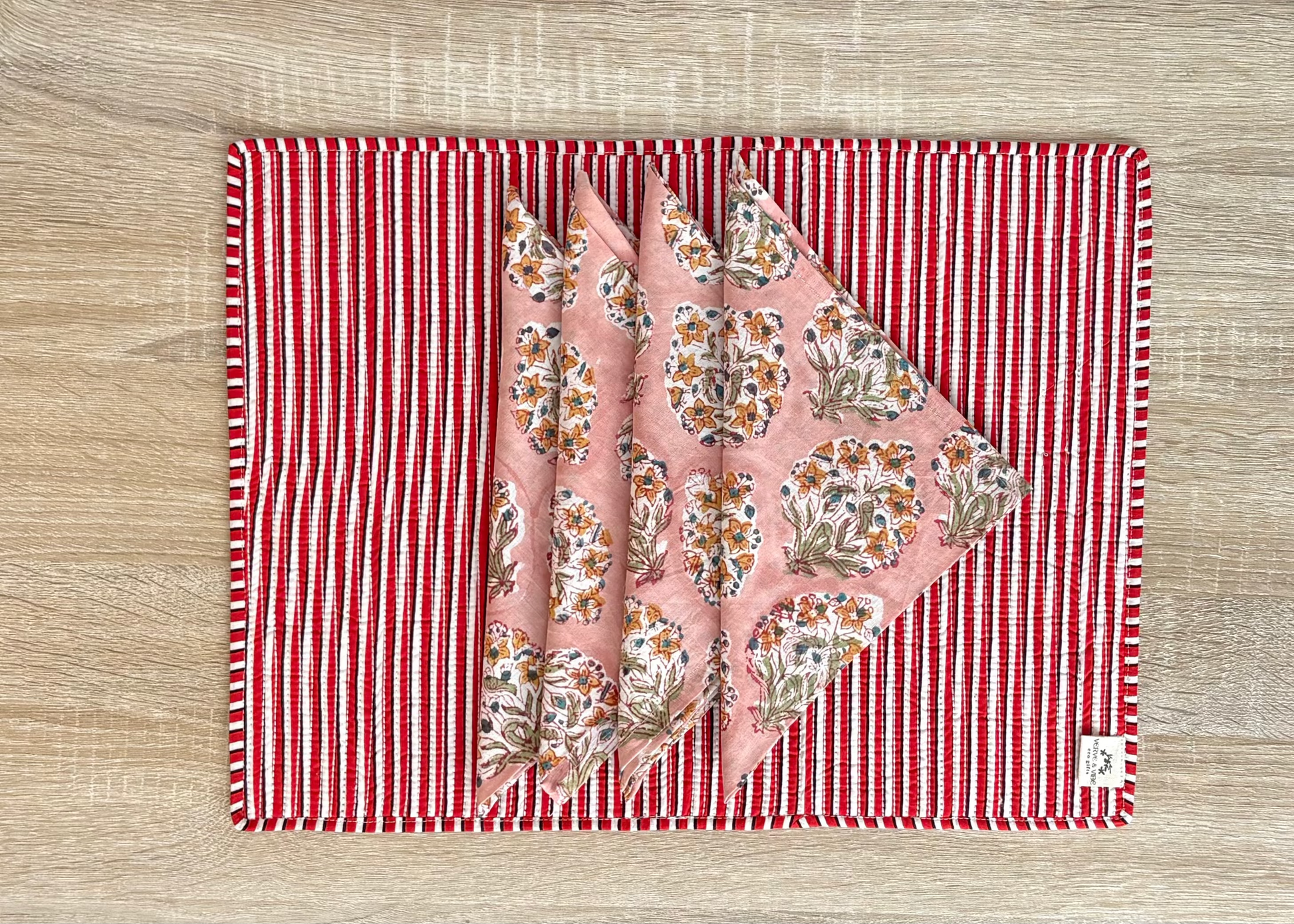 Floral fabric on a red and white striped mat on a wooden surface