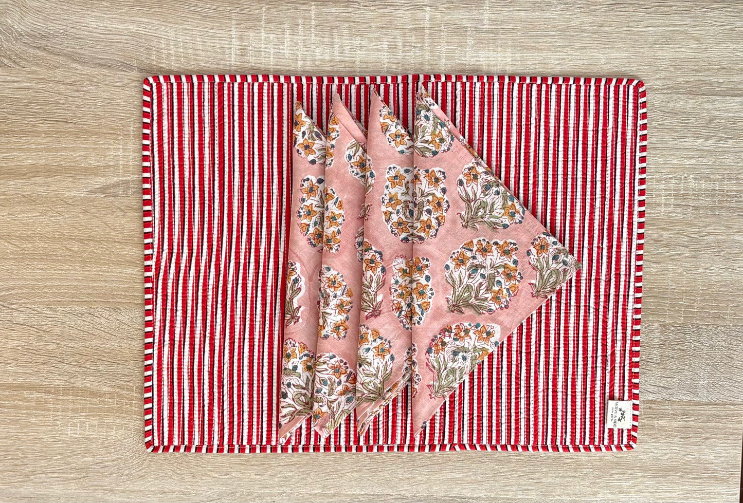 Floral fabric on a red and white striped mat on a wooden surface
