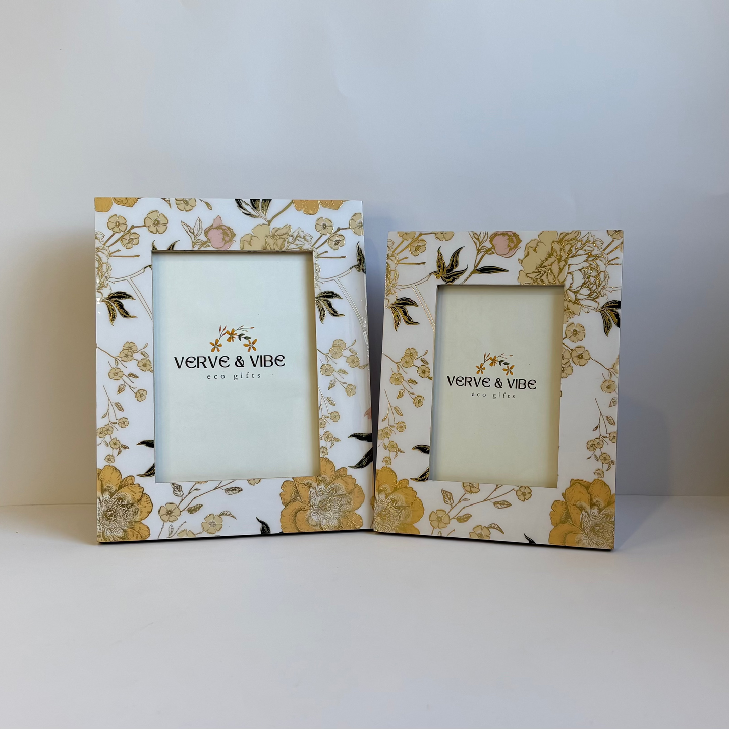 Two decorative picture frames with floral patterns on a white surface.