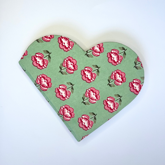 Heart-shaped fabric with red floral pattern on a white background