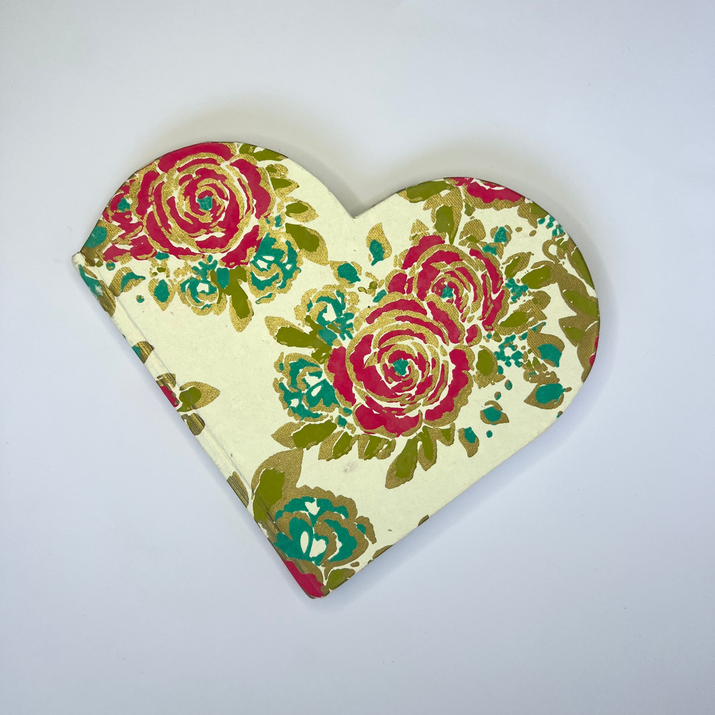 Heart-shaped decorative item with floral pattern on a light gray background