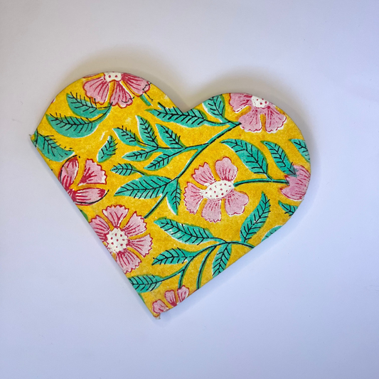 Heart-shaped decorative item with floral pattern on a white background