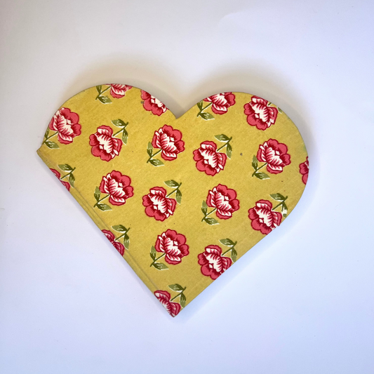 Heart-shaped fabric with red floral pattern on a white background