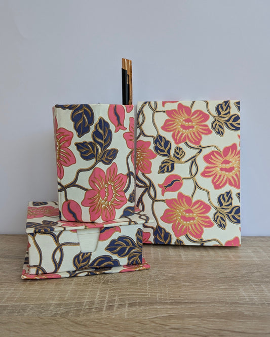 Floral-patterned pouches on a wooden surface with a light gray background