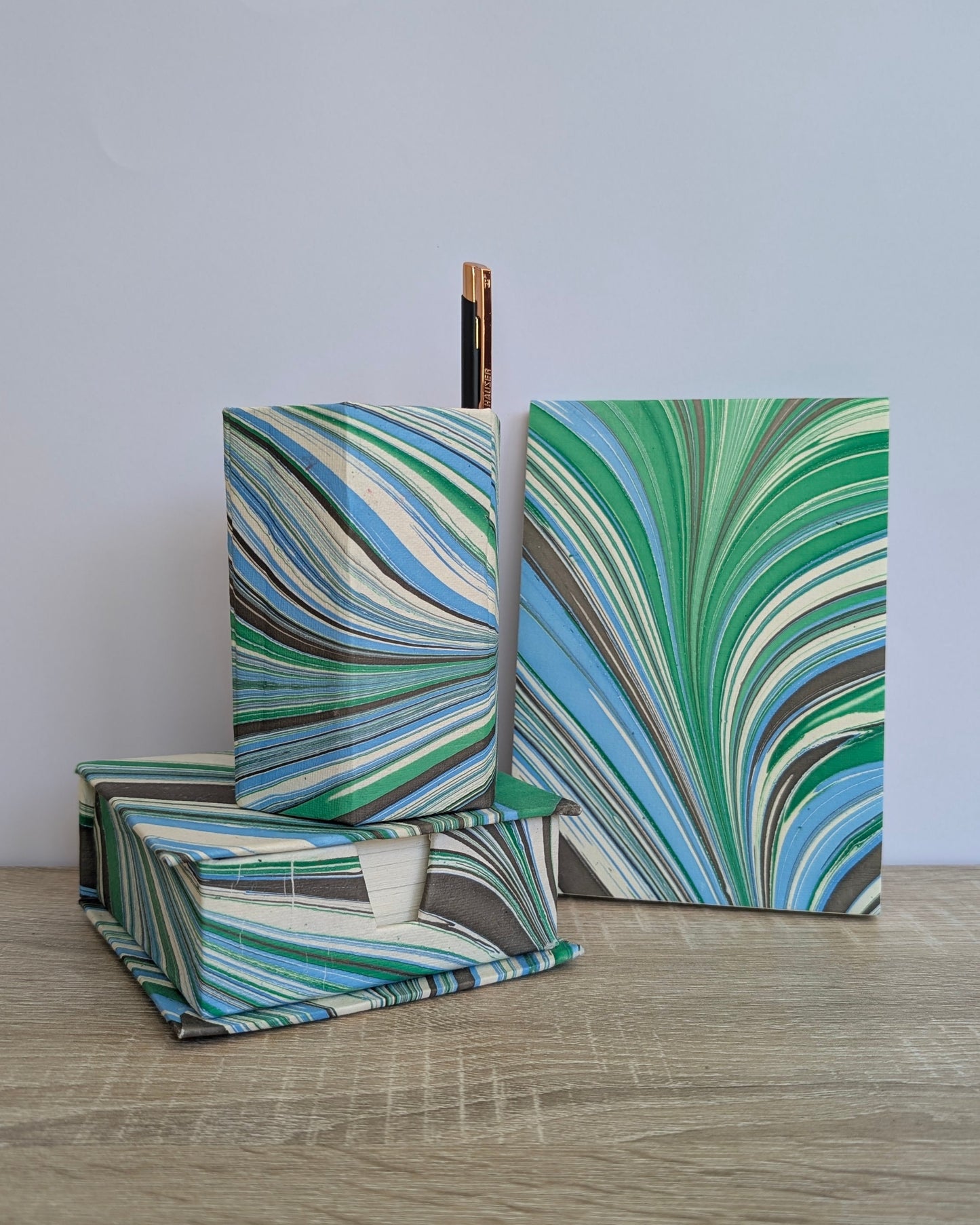 Marbled green and blue boxes on a wooden surface with a light gray background