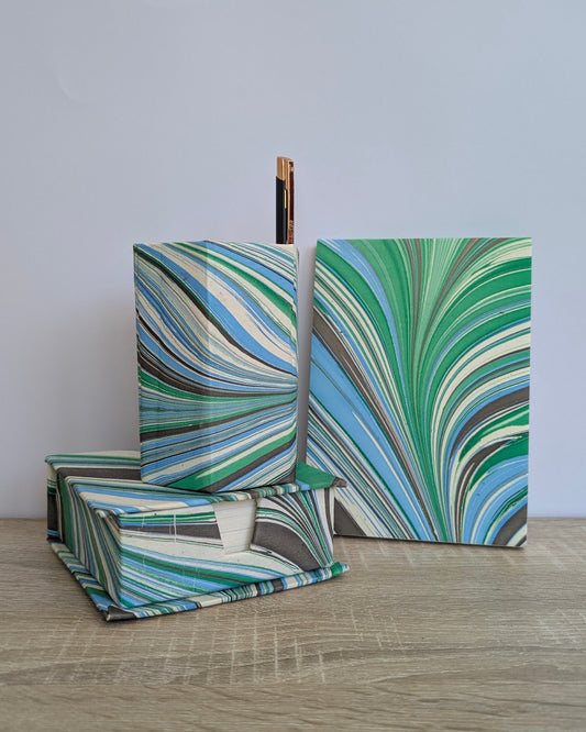 Marbled green and blue boxes on a wooden surface with a light gray background