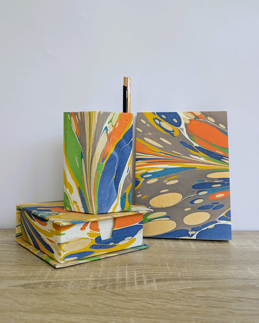 Colorful marbled notebooks with a pen on a wooden surface